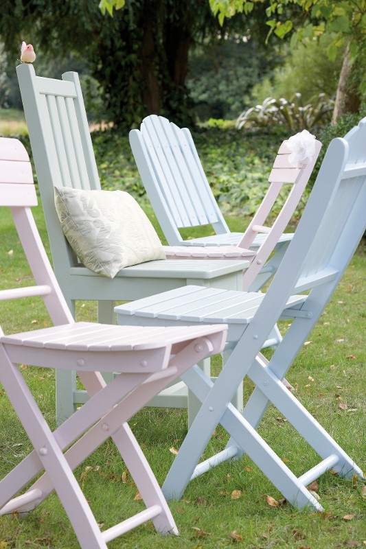A set of outdoor folding chairs, painted an in an assortment of colours