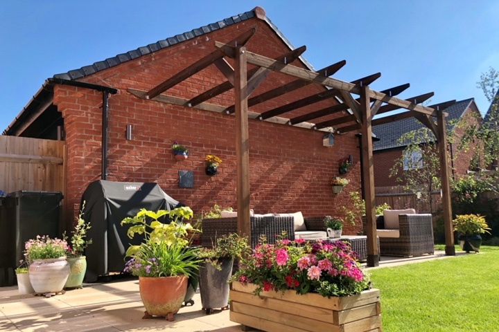 An example of module 2, built against a brick house, and surrounded by a barbeque, wicker furniture, and potted flowers