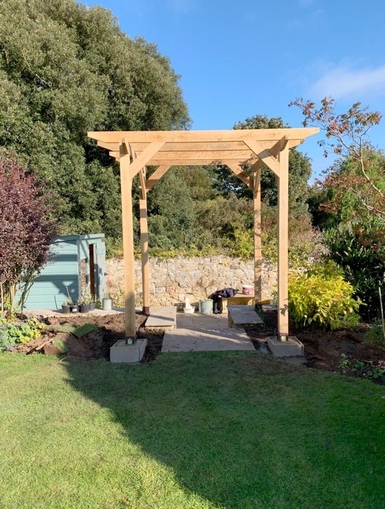 A small standalone pergola which a customer has built over some steps leading down to their driveway